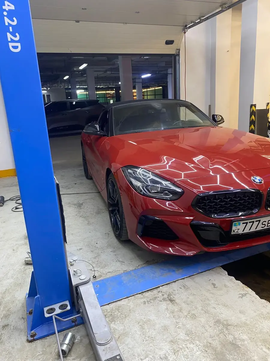 Красный BMW Z4 на подъёмнике — смена цвета авто плёнкой